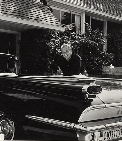 photo of George standing by his car. He's smiling.